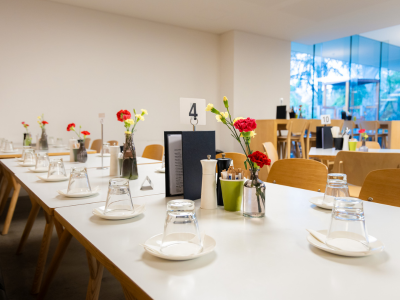 A long table set up at Cafe Vita et flores, adorned with flowers.