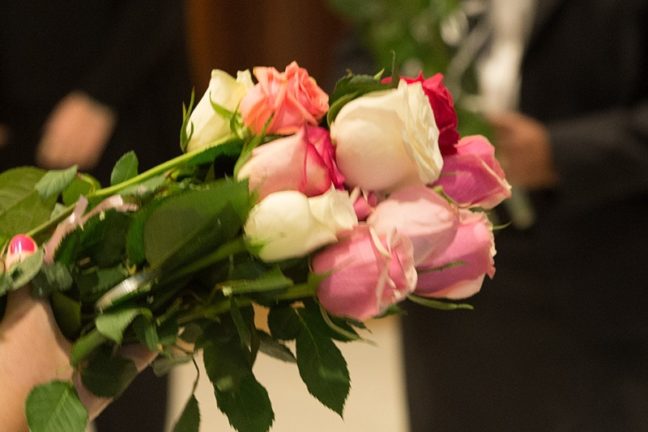 Person holding a bouquet of pink and white roses