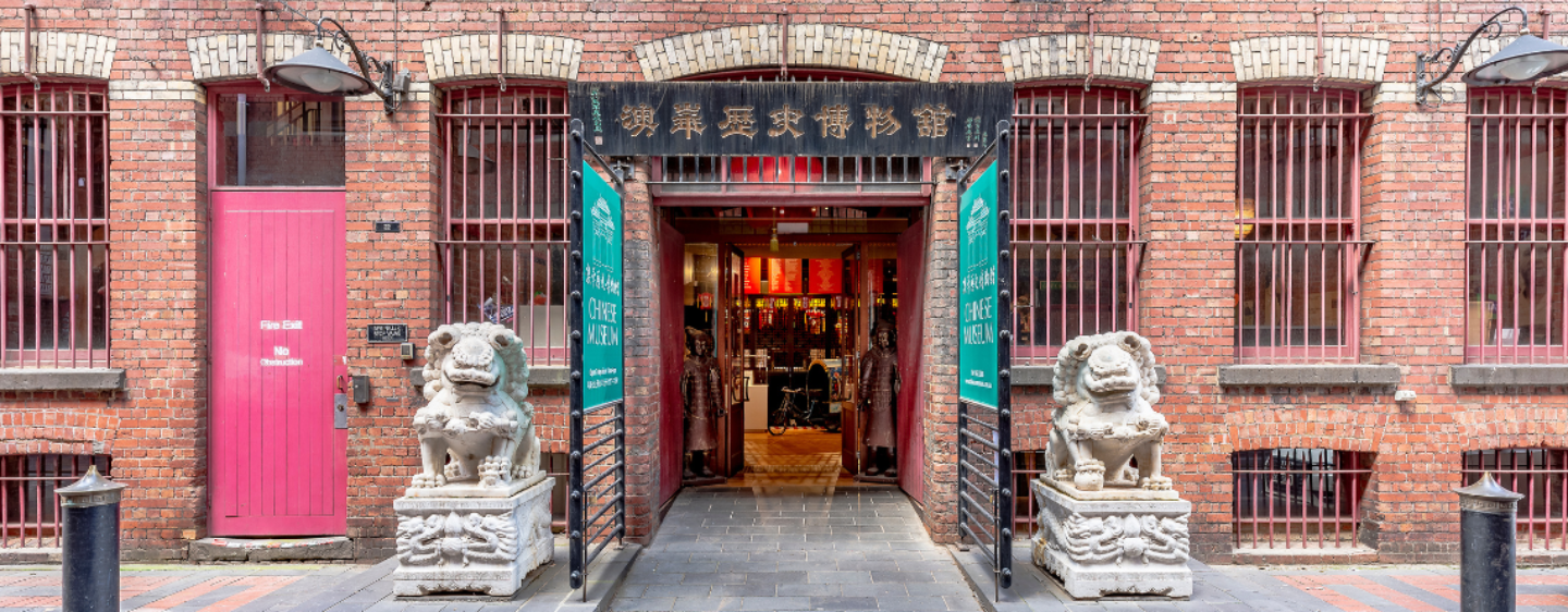 An image of the front door of the Museum of Chinese Australian History, a doorway flanked by two ornate statues